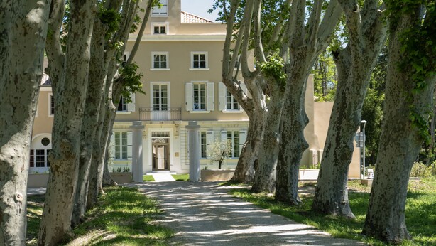 A pathway leading to a building with a classical architectural style, surrounded by trees. - Château de L'Insolas (Villeneuve-lès-Avignon)