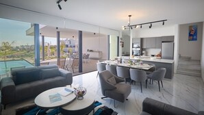 Ein geräumiger Wohnbereich mit Esstisch, Sofas und Blick ins Freie.