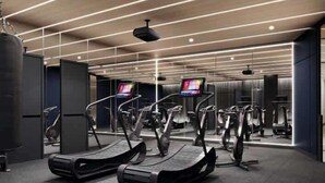 Ein modernes Fitnessstudio mit Laufbändern, Gymbällen und einer Gewichtshalterung.