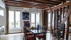 Un comedor con mesa de madera, sillas e iluminación colgante.