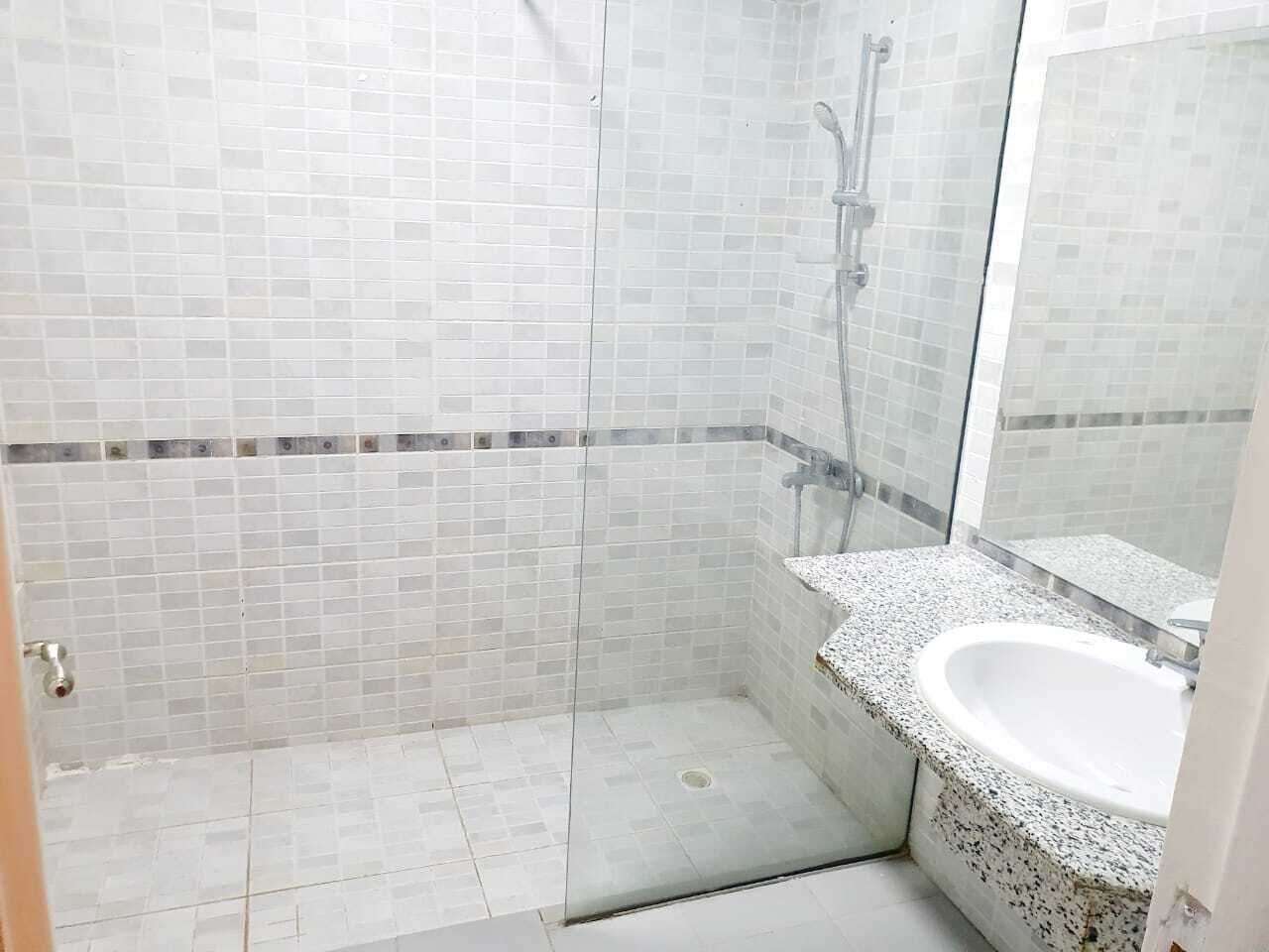 Un bagno con doccia, lavandino e specchio.