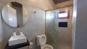 A bathroom with a white sink, toilet, and a glass-enclosed shower.