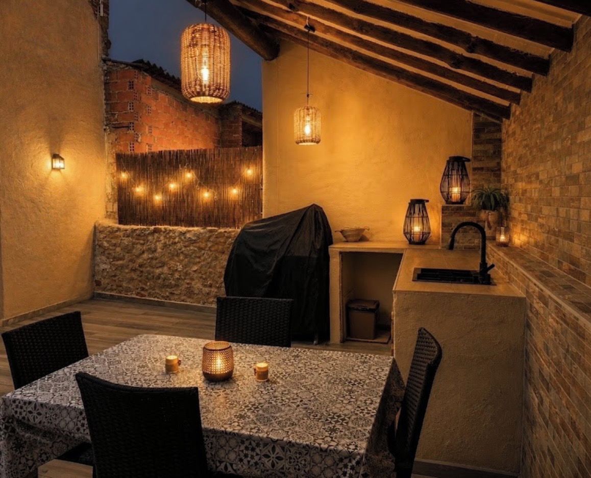 Une terrasse extérieure avec une table, des chaises et un barbecue.