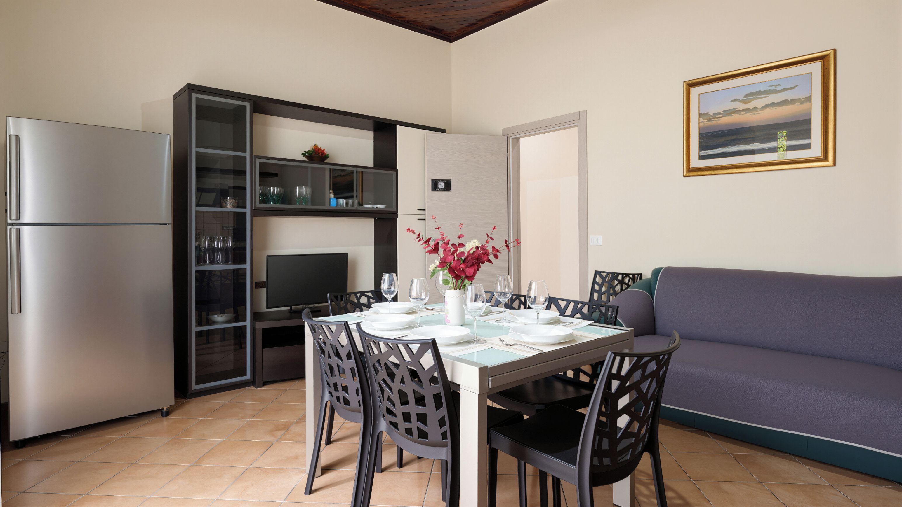 Un espacio habitable compacto con comedor, kitchenette y sofá.