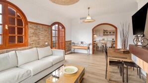 A spacious living area with a sofa, dining table, and kitchen in the background. - 'Roque Bentayga' with Mountain Views, Wi-Fi, and Air Conditioning (Las Palmas)