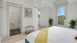 A bedroom with a bed, a bedside table, a window, and a door. - The Wynford Romantic Amalfi Escape (Elora)