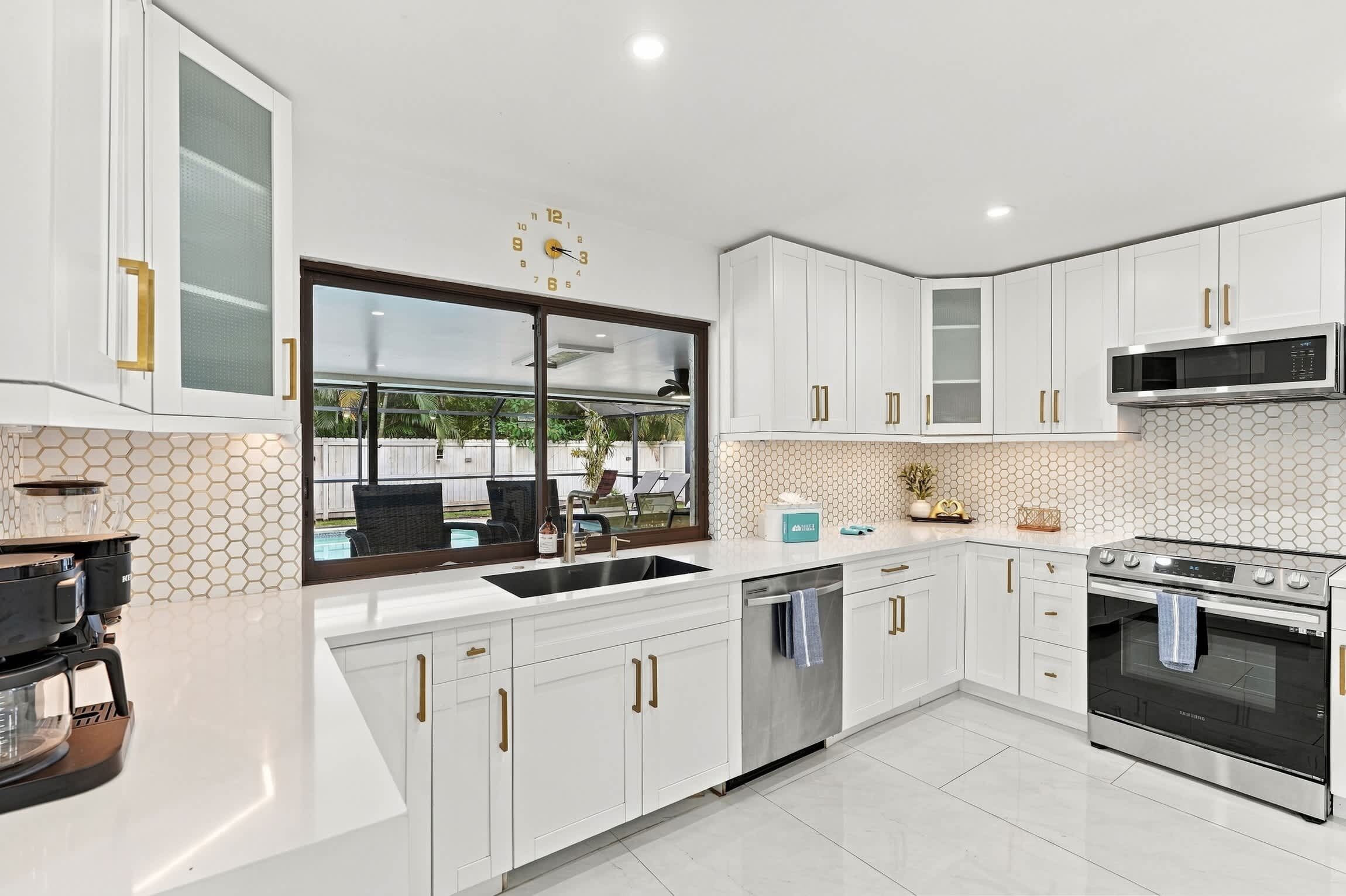 A modern kitchen with white cabinets, a stainless steel microwave, and a dishwasher.