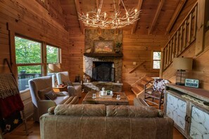 A cozy cabin interior with a stone fireplace, wooden walls, and a comfortable seating area. - FamilyRetreat:Sauna·KingBeds·Backyard·RemoteWork (Ellijay)