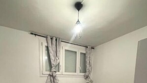 Ein kleiner, einfach eingerichteter Raum mit einem Bett, einem Schreibtisch und einem runden Tisch.