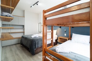 A room with two beds, wooden headboards, and built-in shelving.