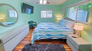 A bedroom with a bed, a chair, a desk, a mirror, a ceiling fan, and a window. - Cozy 3br 2ba Winter Haven Getaway Chain of Lakes Downtown (Winter Haven)