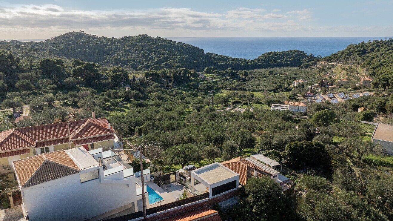 Un quartier résidentiel avec des maisons, une piscine et une vue sur la mer.