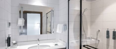 A modern bathroom with a glass-enclosed shower, a double sink vanity, and a mirror above the vanity.