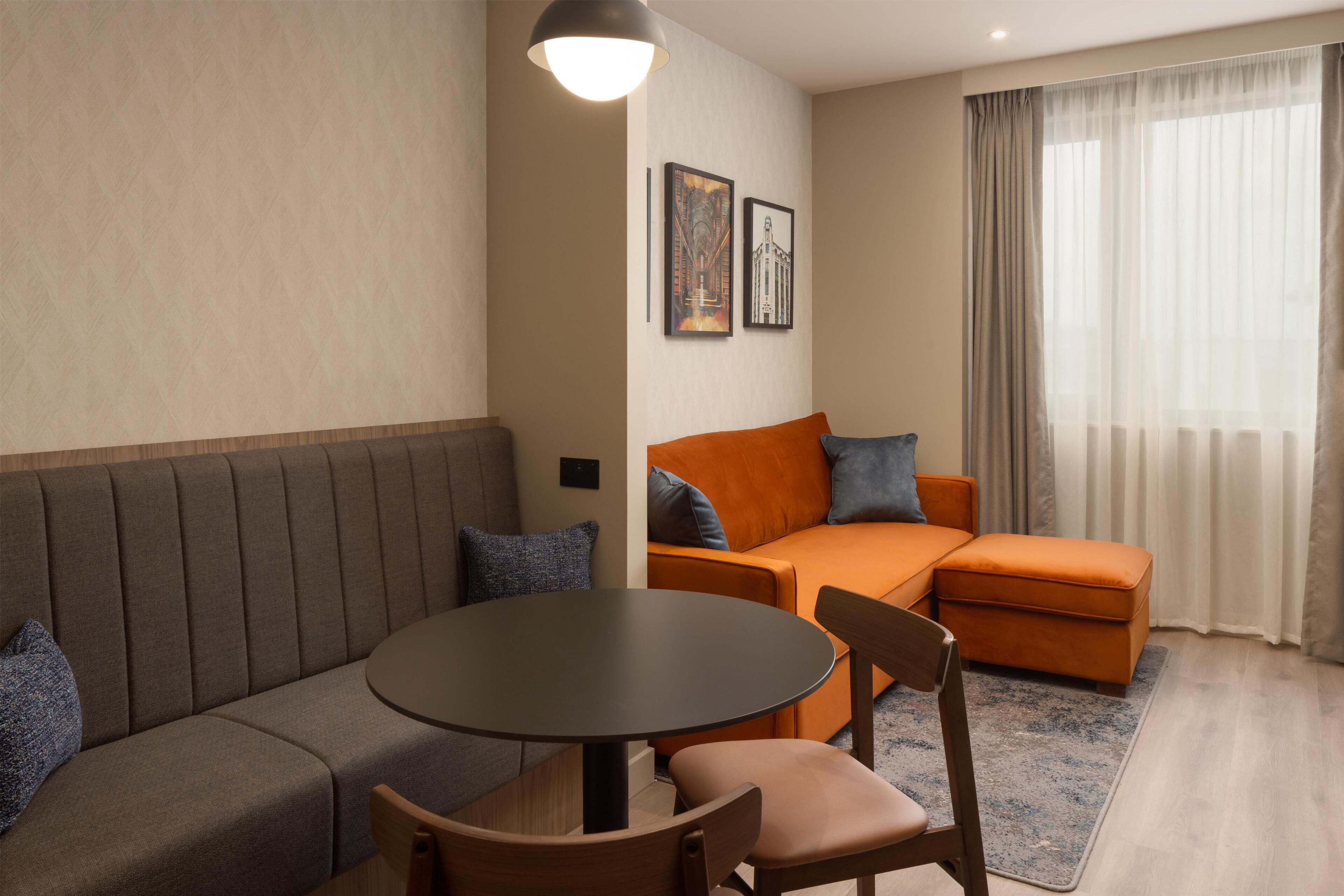 A modern living room with a sofa, a round table, and a couch.