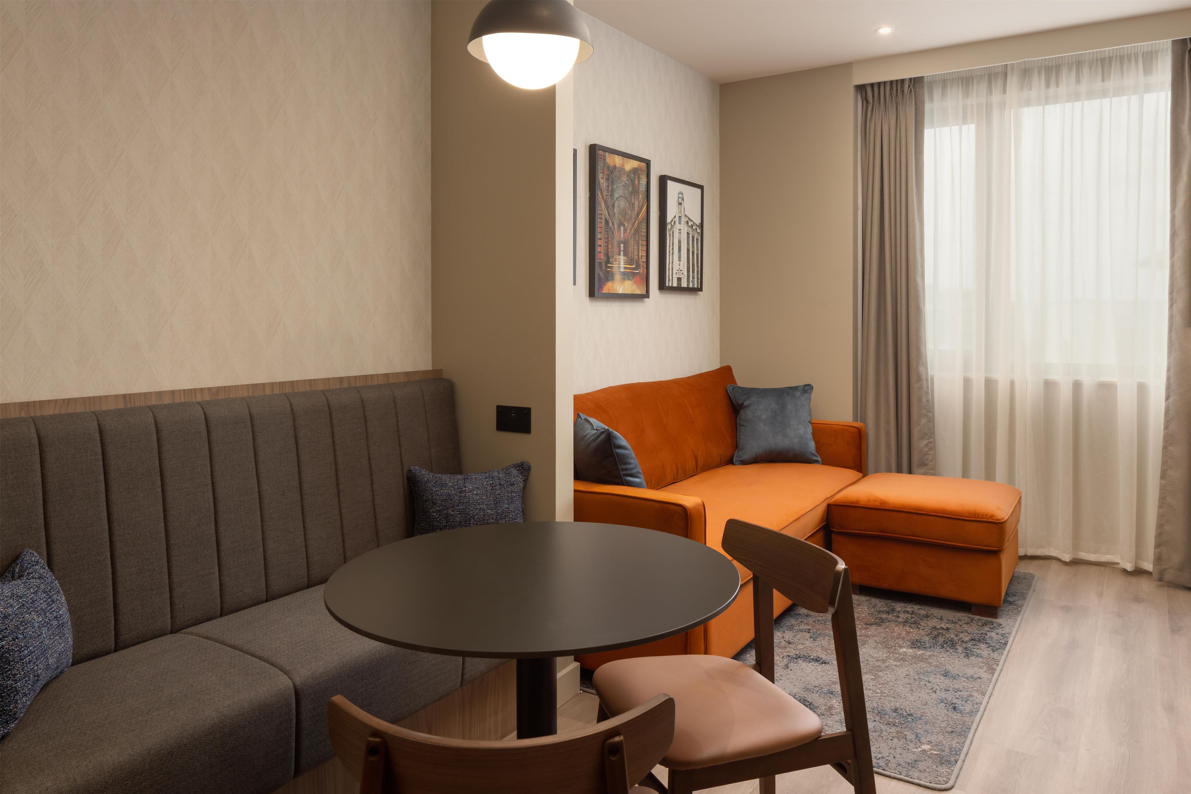 A modern living room with a sofa, a round table, and a couch.