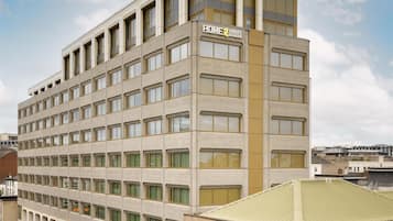 A multi-story hotel with a beige facade, multiple windows per floor, and a flat roof.