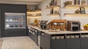 Una cucina moderna con una penisola colazione, diversi alimenti e una macchina per il caffè.