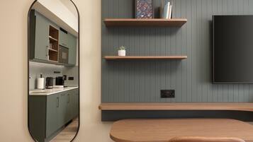 A modern kitchen with a built-in oven, a coffee maker, and a kettle on the counter.