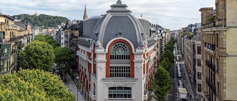 A historic building with a prominent dome and arched windows, surrounded by trees and other buildings.
