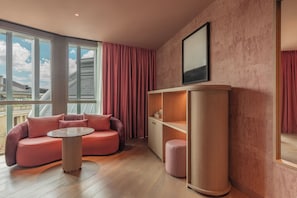 A modern interior with a sofa, a small round table, and a tall column. - Hotel Palacio Bellas Artes San Sebastián, Curio Collection by Hilton (San Sebastián)