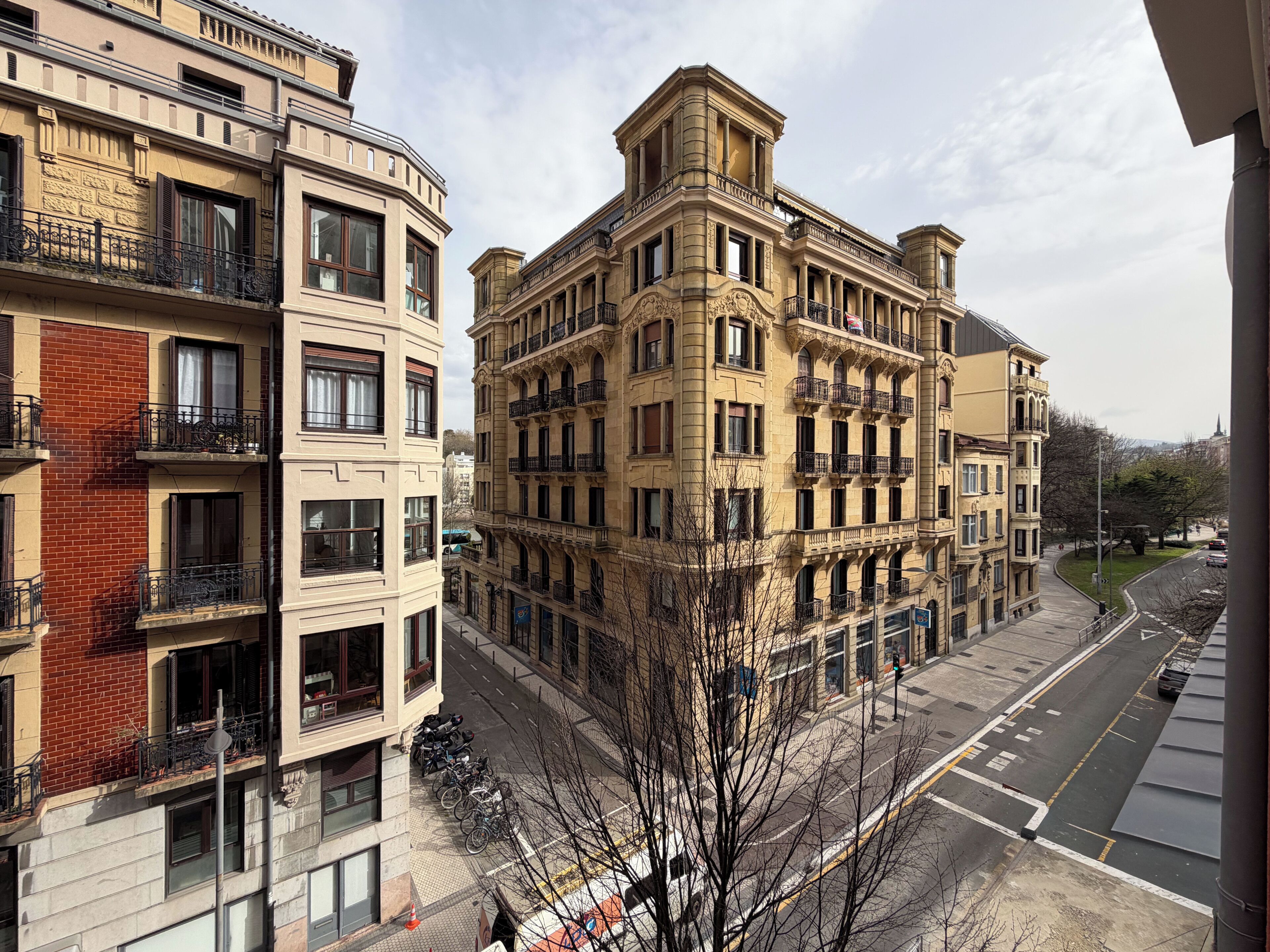 A multi-story building with balconies and a street view.
