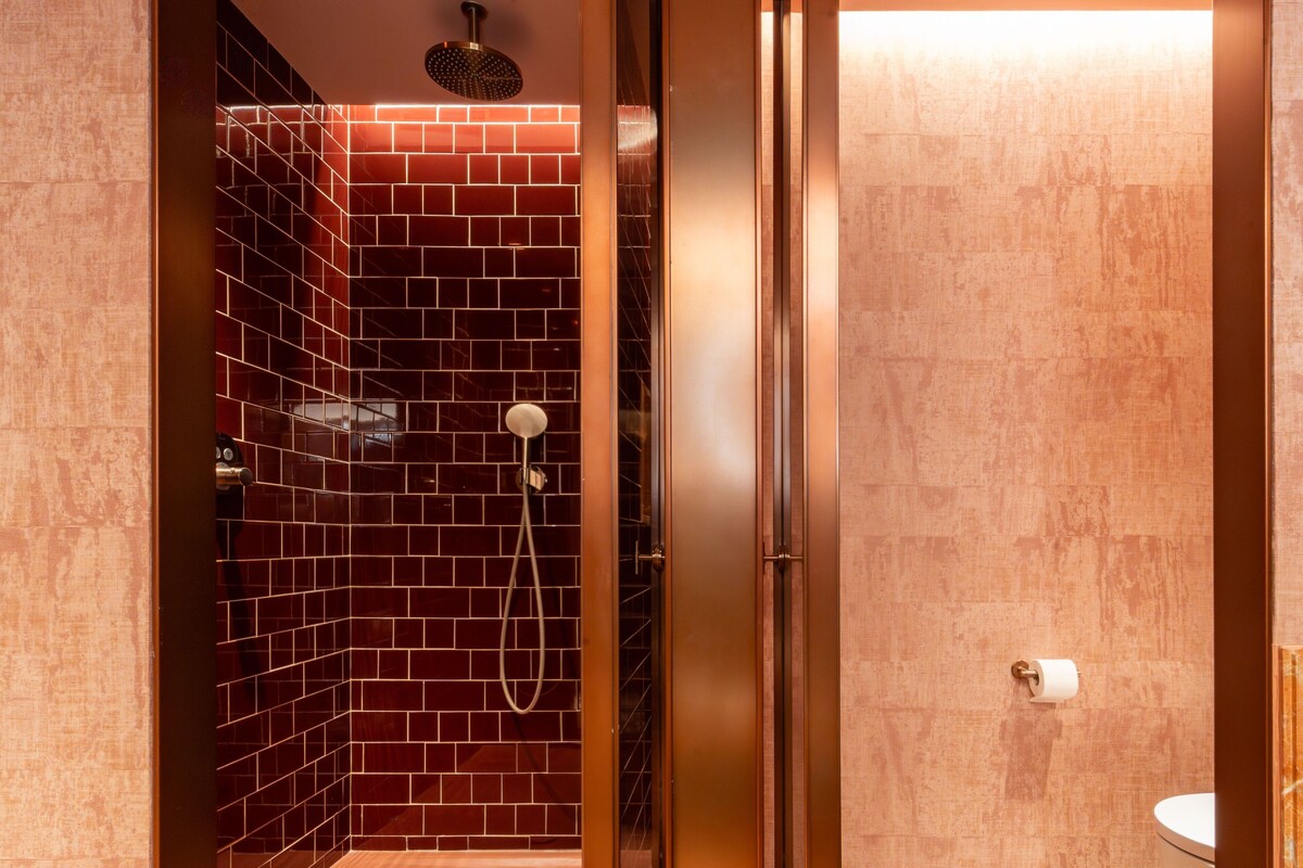 A bathroom with a shower, a toilet, and a sink.