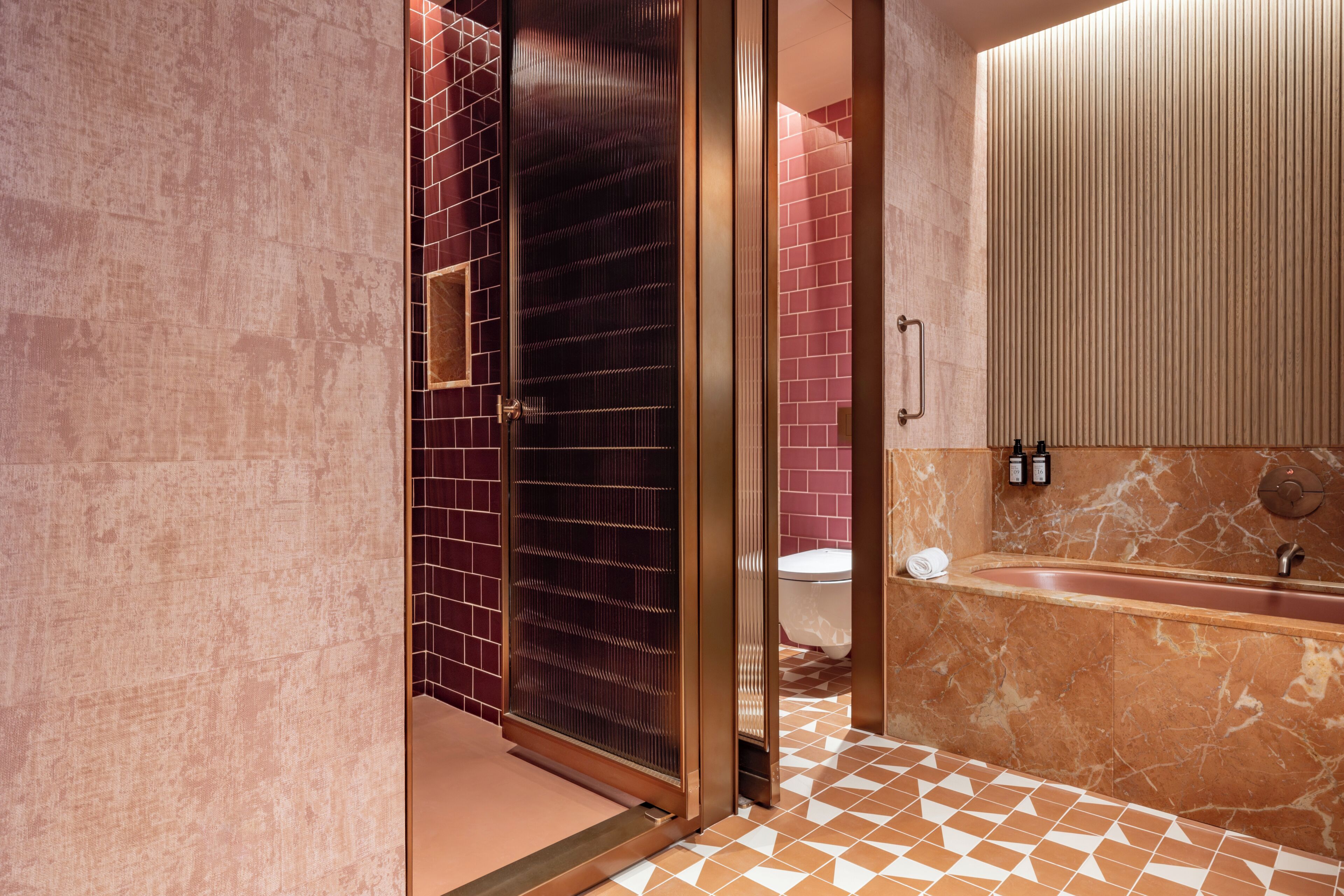 Une salle de bain dotée d’une douche à parois de verre, d’une baignoire en marbre et d’un sol carrelé.
