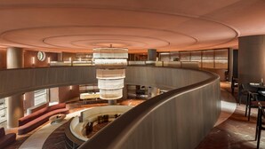 A spacious, modern lobby with a central chandelier, curved seating areas, and a mezzanine level. - Hotel Palacio Bellas Artes San Sebastián, Curio Collection by Hilton (San Sebastián)
