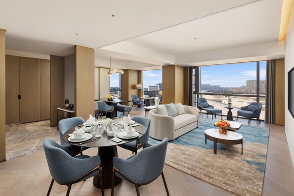 Une chambre d’hôtel moderne avec un coin repas, un canapé et une vue sur la ville.