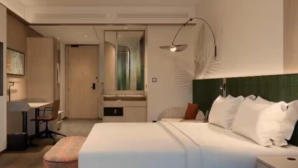 A modern hotel room with a large bed, a desk, and a chair. - Hilton Garden Inn Huai'An Jinhu (Huai'an)
