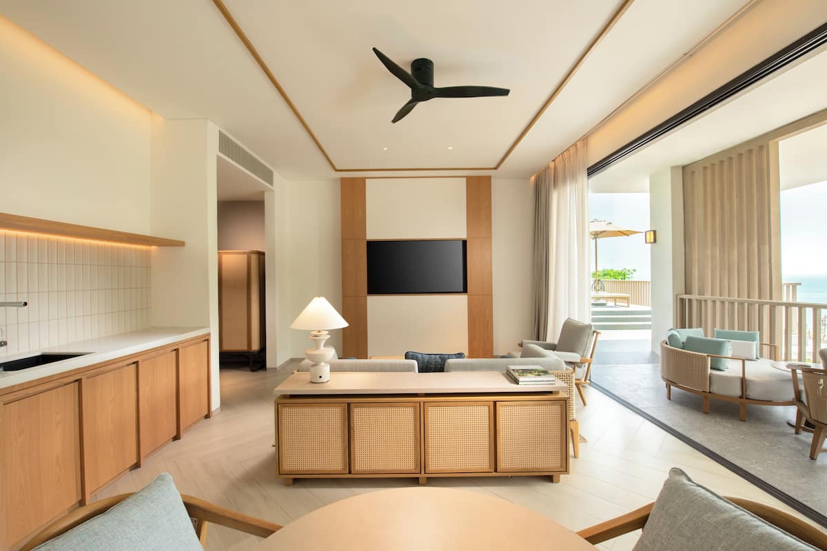 Une chambre d’hôtel moderne dotée d’une cuisine, d’un coin repas et d’un balcon avec vue.