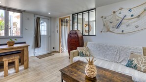 Een woonkamer met een houten tafel, een bank en een decoratief wandobject.