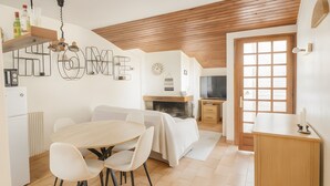 Eine moderne Küche mit Essbereich, Holzboden und Kamin.