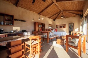 A spacious kitchen with wooden furniture, a dining area, and a large window providing natural light. - Spacious luxury villa minutes from town, nearby beaches and attractions! (San Juan del Sur)