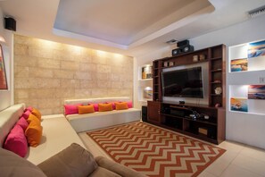 A modern living room with a sofa, television, and decorative shelves. - Spacious luxury villa minutes from town, nearby beaches and attractions! (San Juan del Sur)