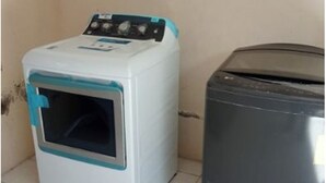 A compact washer and dryer unit with a control panel, placed on a tiled floor against a plain wall. - Spacious luxury villa minutes from town, nearby beaches and attractions! (San Juan del Sur)