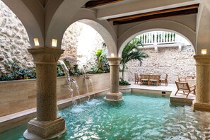 A pool area with stone columns, water features, and outdoor seating. - Palacio del Agua by Faranda Boutique (Cartagena)