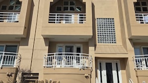 A multi-story building with balconies, windows, and a door. - Talk about Location!!!!    Across from the Beach,Lucy & the GreenHouse (Margate City)