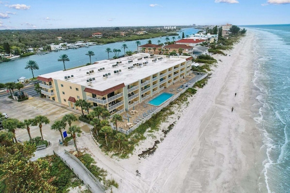 Un hôtel situé en bord de mer, doté d’une piscine, de plusieurs balcons et offrant une vue sur l’océan.