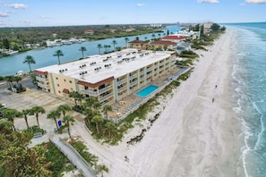 Un hôtel situé en bord de mer, doté d’une piscine, de plusieurs balcons et offrant une vue sur l’océan.