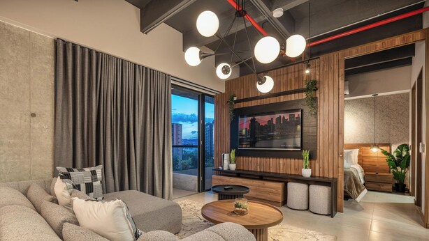 Een moderne woonkamer met een grote bank, een salontafel en een flatscreen televisie bevestigd aan een houten wand. Er is een schuifdeur die leidt naar een balkon met uitzicht op de stad.