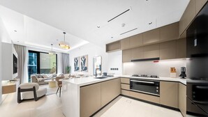 Een moderne keuken met een centraal eiland, ingebouwde apparatuur en een groot raam met uitzicht op de omgeving.