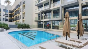 Ein modernes Hotel mit einem Dachpool, Außenbereich zum Sitzen und einem mehrstöckigen Gebäude mit Balkonen.
