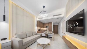 Una sala de estar moderna con un sofá, una mesa de centro y un televisor montado en la pared.