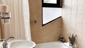 A bathroom with a bathtub, a toilet, and a sink. - Hosteria Andina (Esquel)