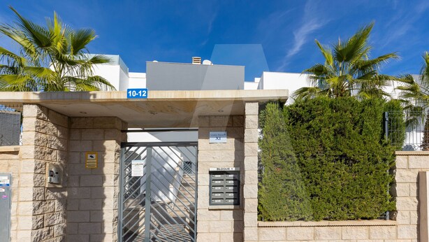 A building entrance with a metal gate, a mailbox, and a sign indicating '10-12'. - Casa Marina in Guardamar (Guardamar del Segura)
