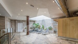 A spacious indoor area with a high ceiling, a central column, and a seating area with chairs and plants. - Casa Marina in Guardamar (Guardamar del Segura)