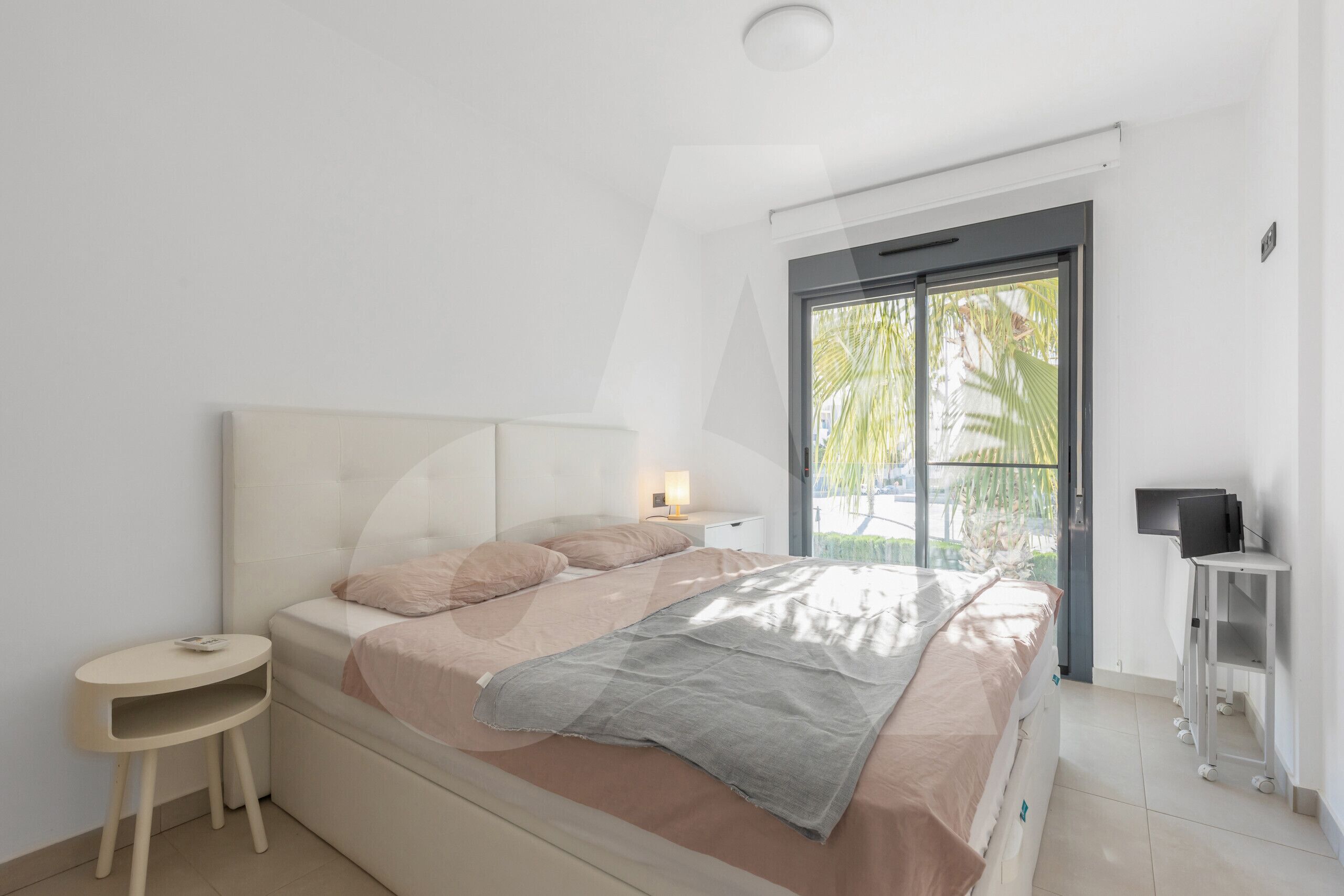 Ein modernes Schlafzimmer mit Bett, Nachttisch und Schreibtisch mit Stuhl.