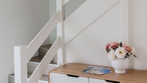 Een trap met witte leuningen en een houten vloer.