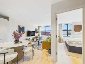 Eine moderne Wohnung mit Essbereich, Wohnzimmer und Schlafzimmer.